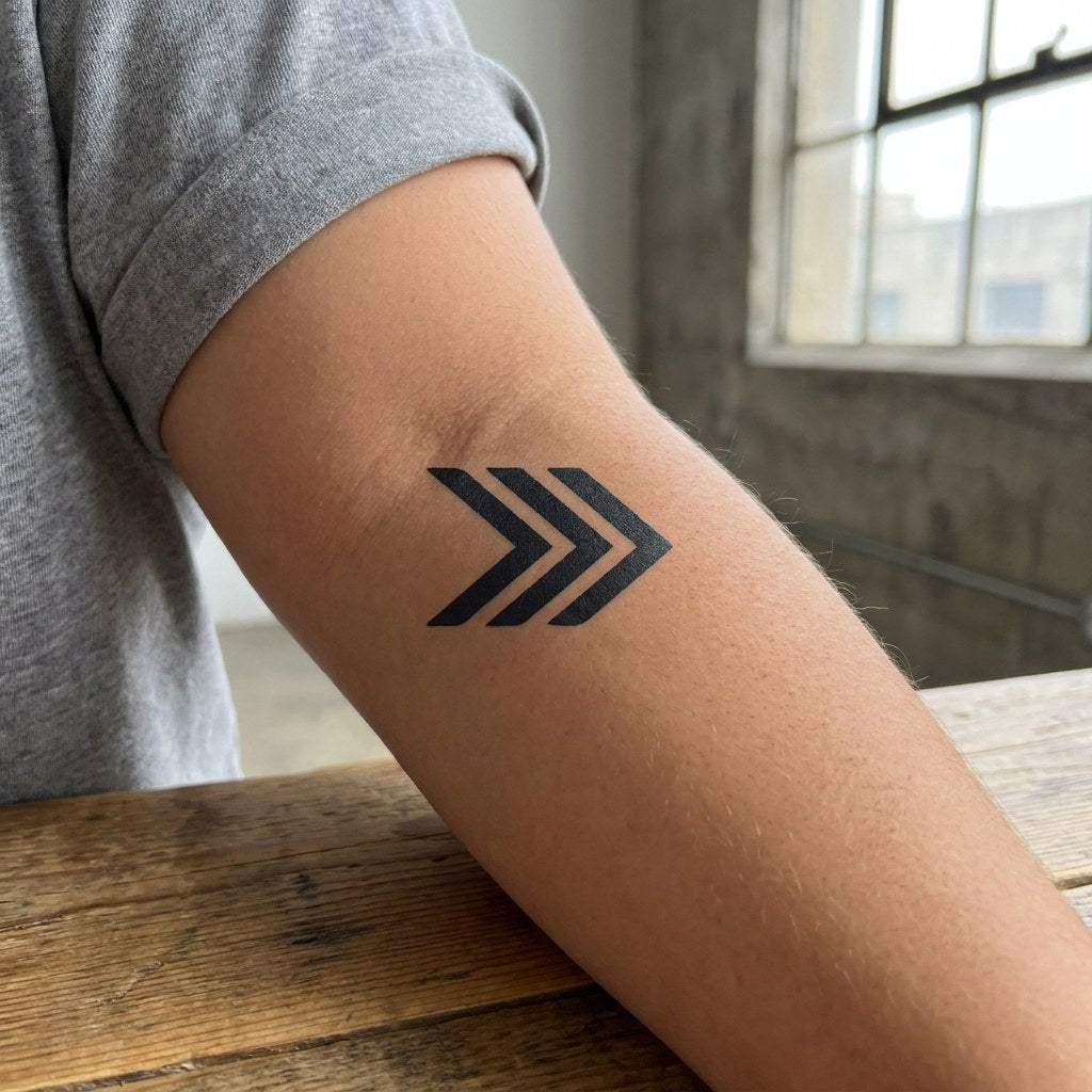 Triple chevron arrow temporary tattoo in solid blackwork on white background, three stacked right-pointing geometric chevrons.