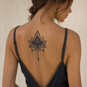 Ornamental lotus mandala chandelier temporary tattoo with dotwork and hanging teardrop pendant on white background.
