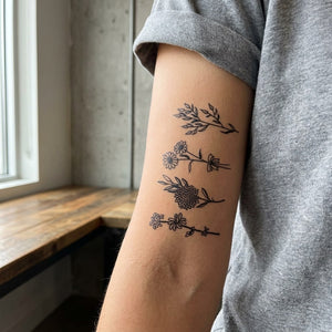 Fineline botanical flower branch set temporary tattoo — four sprigs including daisy, chrysanthemum and wildflower stems on white background.
