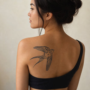 Classic swallow in flight temporary tattoo with detailed linework and forked tail, traditional style on white background.