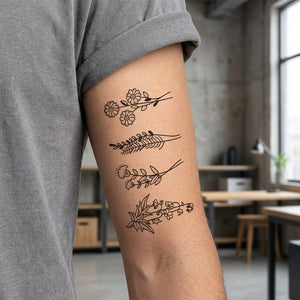 Set of four fineline botanical stem temporary tattoos — daisy branch, herb sprig, bellflower, and leafy vine — on white background.