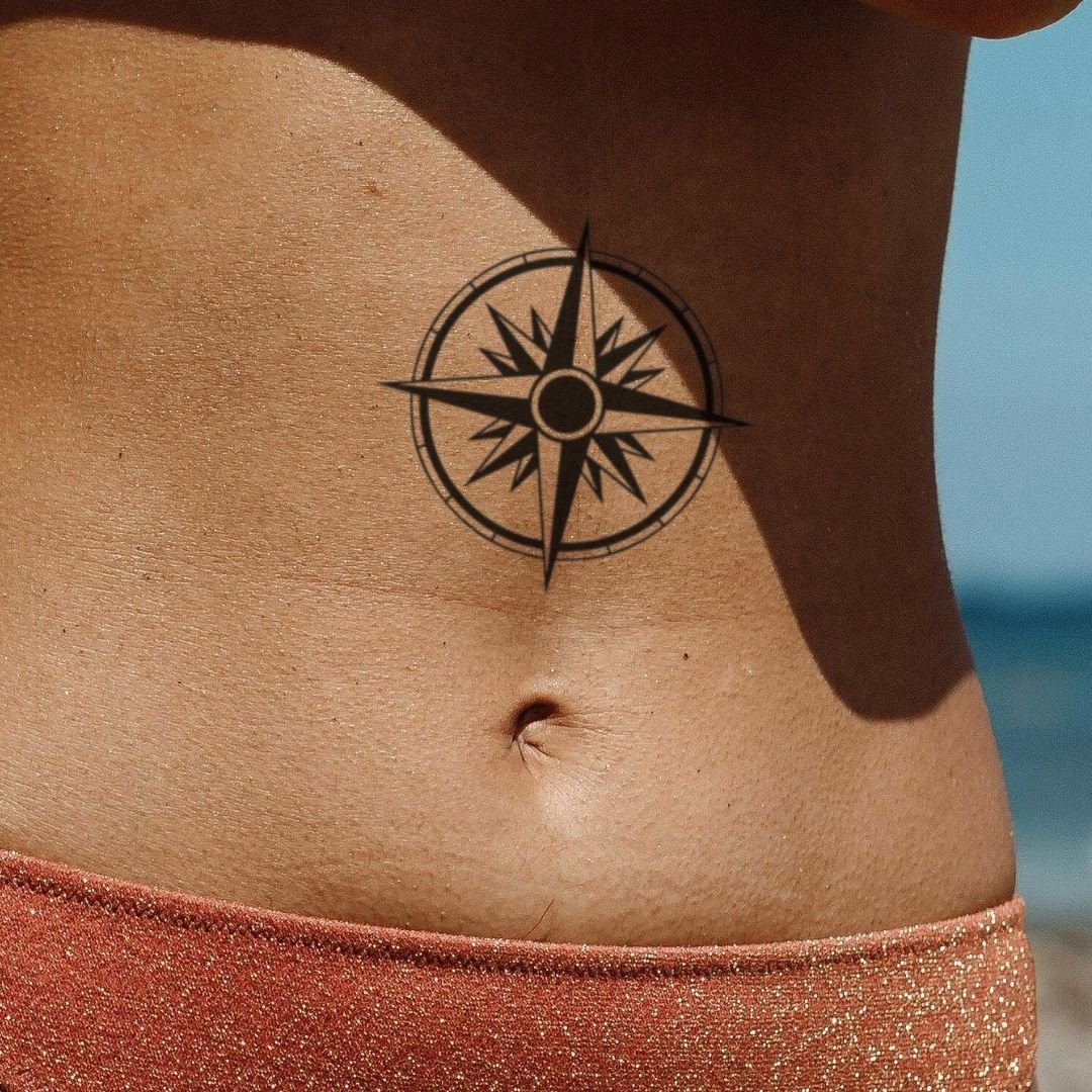 Geometric compass rose tattoo — structured lines and symmetry in blue-black